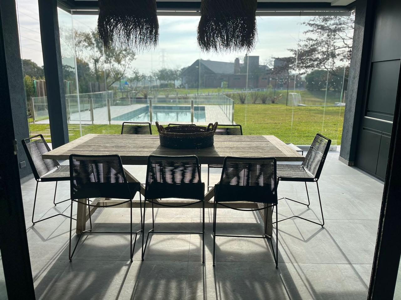 Comedor vidriado con vista a la galería y la pileta