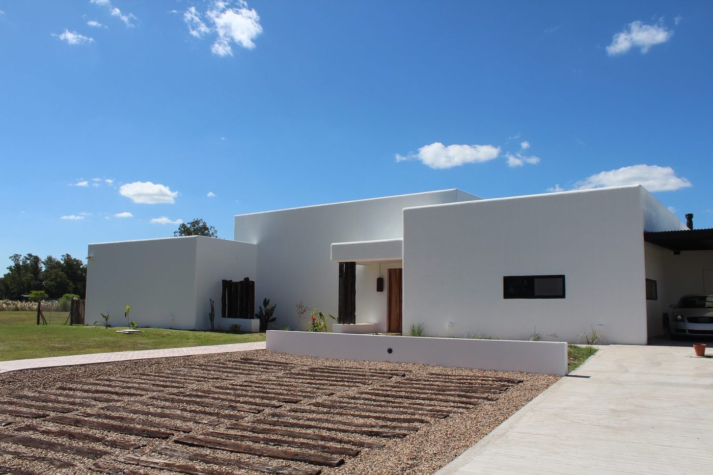Casa blanca de una planta con patio de acceso